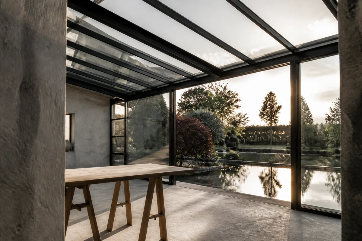 Extension vitree en acier ouverte sur un jardin en bord de bassin